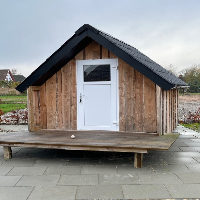 Skur med udhusdør i hvid plast med vindue og sort tag.